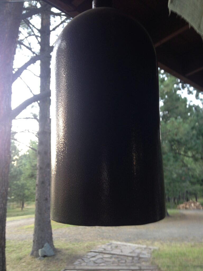 Wallowa Buddhist Temple hanging bell porch stone walkway pines